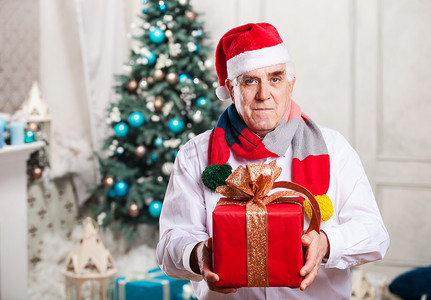 圣诞背景中带礼品盒的老人