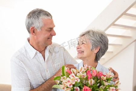 年长的夫妇拿着花束互相微笑