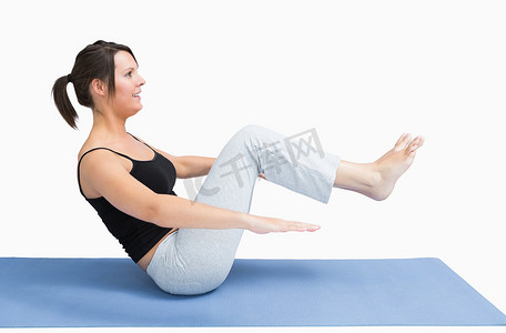 在瑜伽垫上锻炼的年轻女子的侧视图