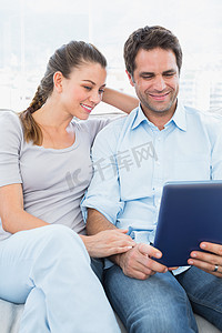 pc首页摄影照片_幸福的夫妻坐在沙发上使用 tablet pc