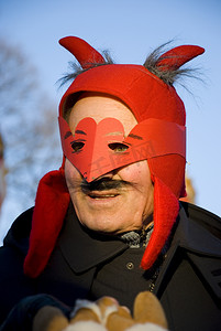 面具仪式摄影照片_戴着红色狂欢节面具的男人