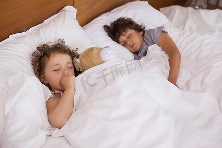 睡在床上的年轻女孩和男孩