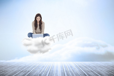 使用笔记本电脑坐在云上的黑发女郎的合成图像