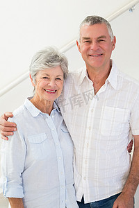 快乐的退休夫妇站着对着镜头微笑