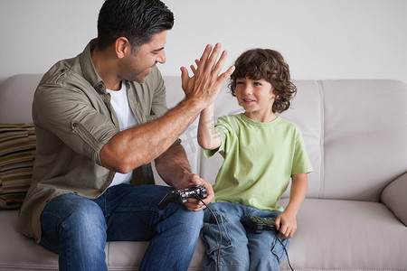 父亲和儿子在客厅玩电子游戏