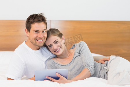 pc首页摄影照片_幸福的夫妻在床上使用 tablet pc
