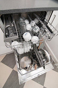 闪亮登场摄影照片_带有干净闪亮的盘子和厨具的洗碗机