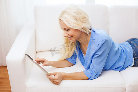 微笑的女人在家里用 tablet pc 电脑