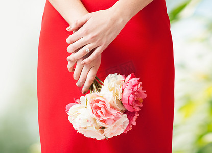 女人手上拿着鲜花和戒指