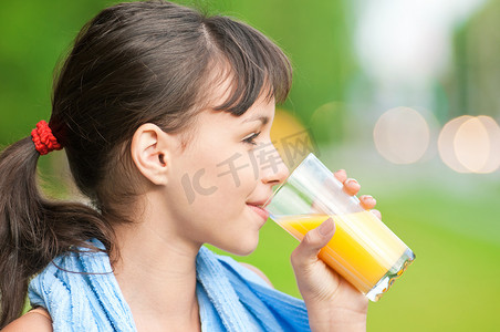喝果汁的女孩摄影照片_运动后喝果汁的女孩