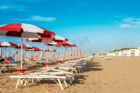 沙滩上的红色和白色遮阳伞和太阳伞