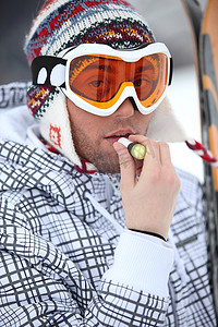 涂抹润唇膏的滑雪者