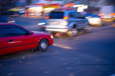 运动模糊在十字路口的红色汽车照片。