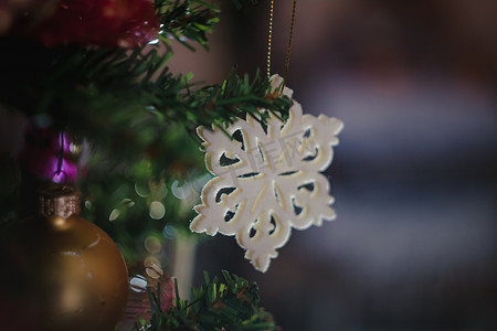 红蓝白摄影照片_圣诞玩具以蓝-红-白复古星形雪花的形式出现在圣诞装饰的圣诞树上。