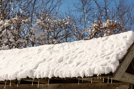 屋顶的碎片与融化的雪和冰柱