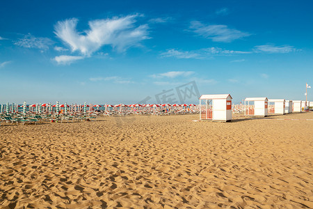 太阳伞摄影照片_沙滩上的红色和白色遮阳伞和太阳伞