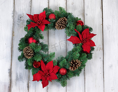 质朴的白色木板上的假日一品红圣诞花环