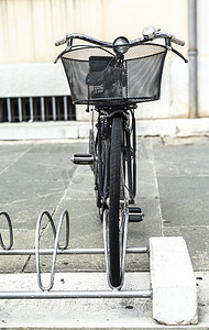 在意大利街道上的自行车架上安装的黑色自行车。
