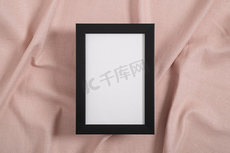 粉色纺织品上带有白色模型的黑色相框