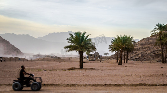 人在沙漠和山的背景下乘坐 ATV