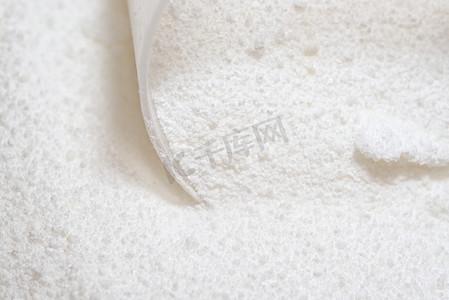洗涤剂摄影照片_洗衣用白色粉末洗涤剂的特写，带塑料勺
