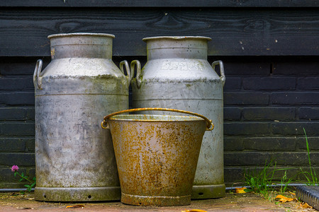 荷兰铁摄影照片_老式农场设备、金属牛奶罐和生锈的旧桶，农业背景
