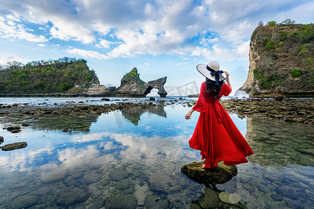 站在印度尼西亚巴厘岛努沙佩尼达岛 Atuh 海滩岩石上的女人。