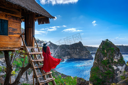 钻石摄影照片_印度尼西亚巴厘岛努沙佩尼达岛 Atuh 海滩树上房子台阶上的小女孩。