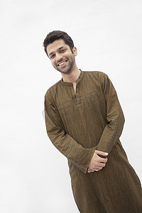 穿着巴基斯坦传统服装的微笑年轻人的肖像，摄影棚拍摄