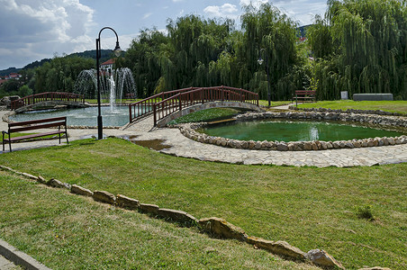 欧洲马其顿德尔切沃镇带人工池塘、喷泉和桥梁的住宅区公共花园全景