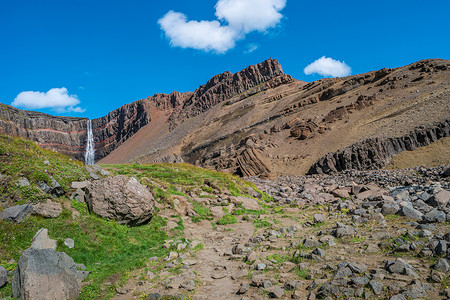 美丽而高大的冰岛瀑布 Hengifoss 和通往它的远足小径，冰岛，夏天，阳光明媚的日子，蓝天