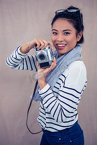 微笑的亚洲女人用相机拍照