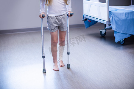 手绘猫走路摄影照片_病房里拄着拐杖走路的女孩