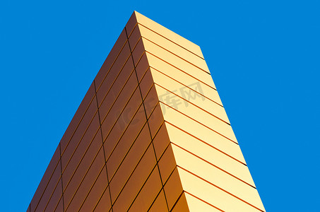 颜色碎片摄影照片_蓝色背景上一座现代黄色建筑的墙壁碎片
