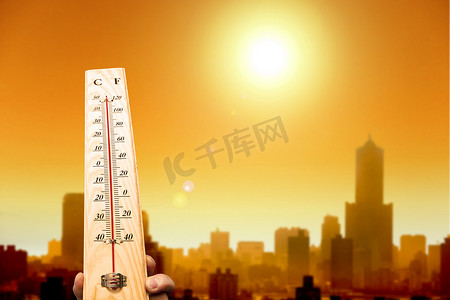 城市的热浪和手上显示的高温温度计