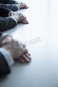 双手合十摄影照片_在商务会议期间，特写商务人士在桌上的双手合十