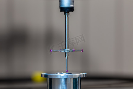 坐标摄影照片_CMM - 坐标测量机 - 接触式探针测量玻璃台面上的铝样品部件。