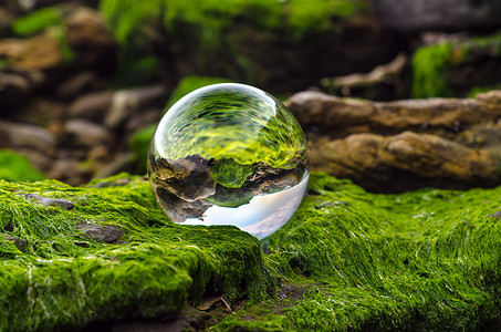 玻璃球透镜位于覆盖着绿泥和反射的石头上