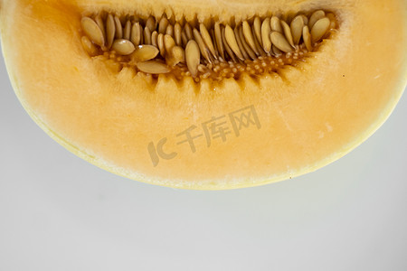 白瓜摄影照片_白盘上的新鲜甜橙瓜作为背景，有选择性地聚焦。