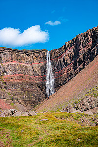 美丽而高大的冰岛瀑布 Hengifoss 和通往它的远足小径，冰岛，夏天，阳光明媚的日子，蓝天