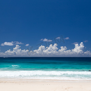 热带海滩，白色沙滩，翡翠水，蓝天白云。
