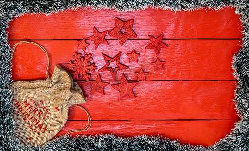 红色木板上的圣诞作文，配有圣诞花环和装饰品。