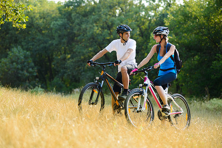 情侣情侣摄影照片_年轻快乐的情侣在户外骑山地自行车