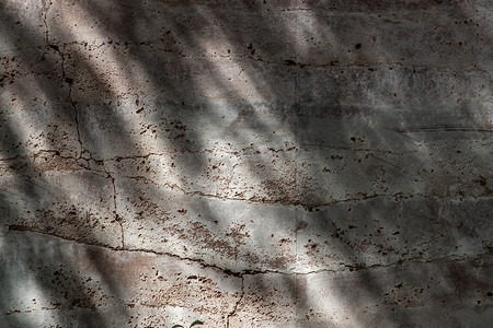 裂痕摄影照片_红砖墙的抽象背景有裂痕或裂缝，在阳光明媚的阳光明媚的日子里装饰着砖的质地。