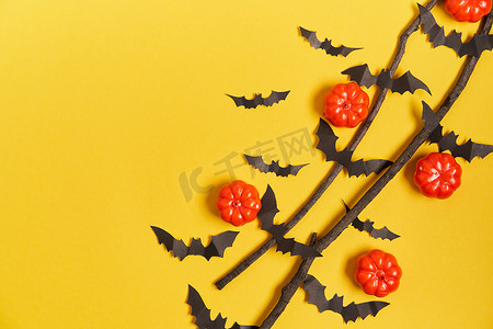 感恩节贺卡贺卡摄影照片_万圣节背景，橙色装饰塑料南瓜黑纸蝙蝠黄卡纸感恩节贺卡