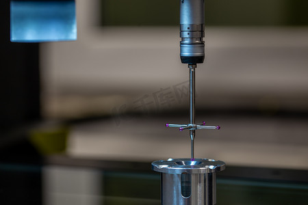 坐标摄影照片_CMM - 坐标测量机 - 接触式探针测量玻璃台面上的铝零件。