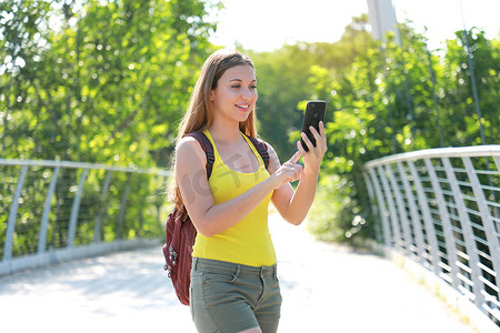 年轻的背包客女孩在自然公园里用手机检查 GPS 坐标。