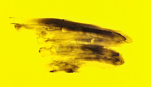 黄黑色摄影照片_黑色涂在黄板上的木炭牙膏，抽象背景
