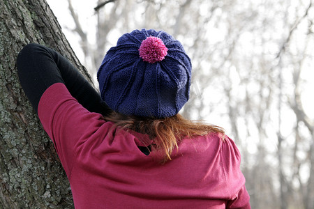毛衫背面摄影照片_蓝色贝雷帽的女孩、一件桃红色毛线衣和红色苹果