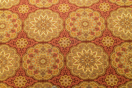 地板上的细节、地毯或挂毯的特写，颜色为黄色、橙色和金色，从上面看有圆形图案